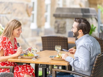 Restaurant Hirsch in Velbert-Langenberg Zwei Personen genießen eine Mahlzeit im Freien an einem Tisch mit Weingläsern in Velbert-Langenberg.