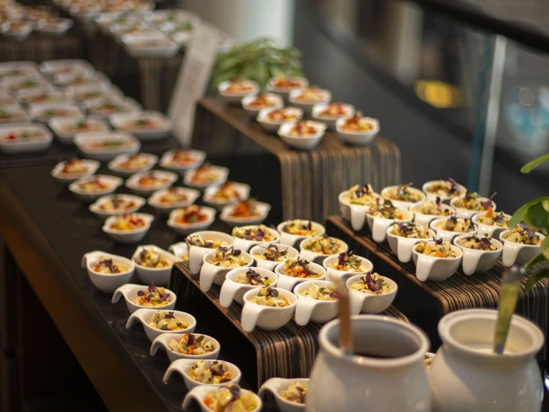 Catering Event-Catering: Viele kleine weiße Schalen mit Häppchen gefüllt stehen auf einem Tisch