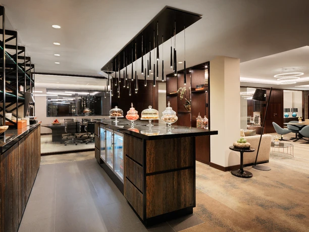 Hyatt-Regency-Cologne-Meeting-Campus-Lounge.jpg Luxuriöse Hotellounge mit moderner Einrichtung, eleganter Bar und stilvoller Sitzbereich im Hintergrund.