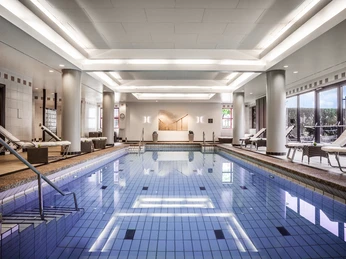 Puls fittness club Eleganter Innenpool mit Liegen, modernen Säulen und großen Fenstern für eine entspannte Atmosphäre.</p>Elegant indoor pool with loungers, modern columns and large windows for a relaxed atmosphere.