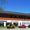 Auto Burgdorf Farchant Haus mit Büro und Ausstellungsraum, davor stehen 3 Autos und ein kleiner Bagger