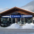 Auto Heigl Farchant Frontansicht eines Hauses mit dem Schild Subaru, Günther Heigl. Davor steht ein Auto, daneben befinden sich ein paar Schneehaufen