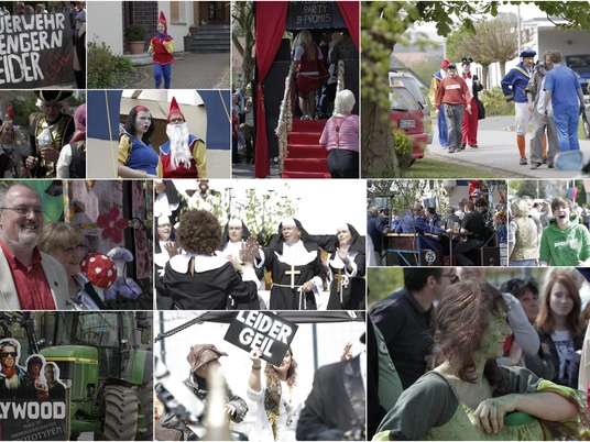 tengern-maifeier-01.jpg Mehrere Menschen in bunter Verkleidung, feiern bei gutem Wetter ein Maifest in einem kleinen Ort.