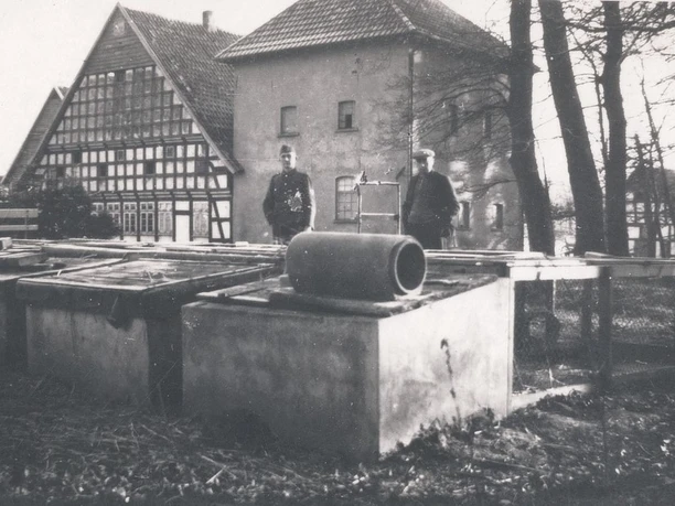 tengern-finkmanns-muehle-03.jpg Historische Ansicht der Finkmanns Mühle in Tengern mit Fachwerkgebäude und zwei Männern im Vordergrund.
