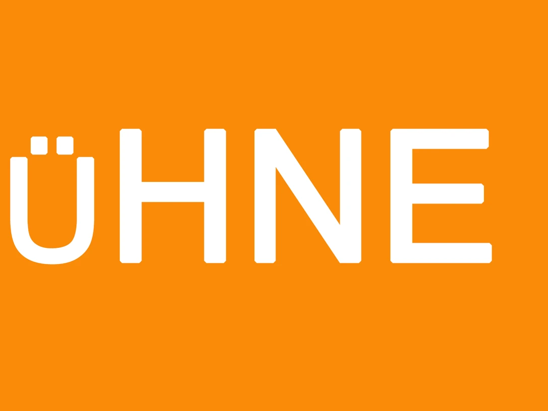 Bühne.jpg Orangefarbener Hintergrund mit dem weißen Schriftzug "BÜHNE" in Großbuchstaben.