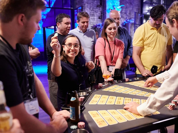 Hopfen & Malz. Bier Black-Jack Tisch Menschen spielen in festlicher Atmosphäre an einem Casino-Tisch mit Pokerchips.