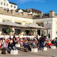 RiasBeachBorkum.png Menschen entspannen auf Liegestühlen vor einem Café bei sonnigem Wetter in Borkum.