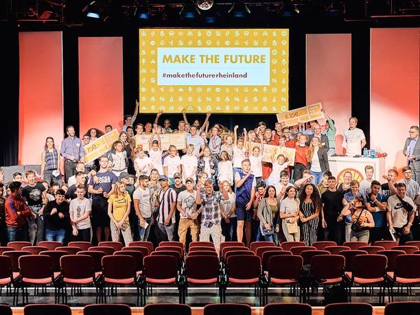 Shell make the future rheinland Gruppenfoto auf Bühne mit vielfältiger Menschengruppe, im Hintergrund ein Schild "Make the Future".</p>