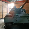 05_DPM_Neue Dauerausstellung_Bereich Kalter Krieg I-min.jpg Ein grüner Panzer aus der Zeit des Kalten Krieges steht in einem Ausstellungsraum neben einer Informationstafel.