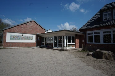 Schule Soderstorf.JPG Eingangsbereich der Grundschule Soderstorf mit roter Backsteinfassade und einem Wandmosaik.