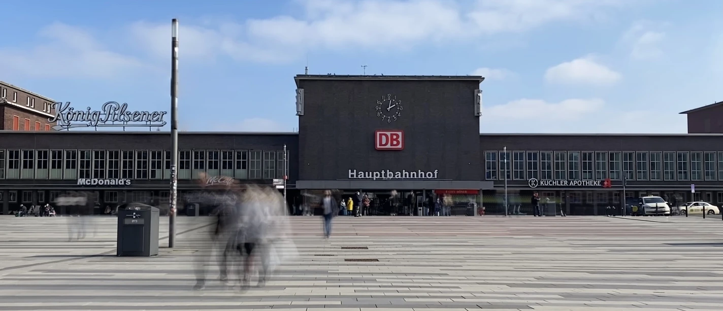 Hauptbahnhof Duisburg Hauptbahnhof Duisburg mit DB-Logo und Menschen auf großem Platz an einem klaren, sonnigen Tag.