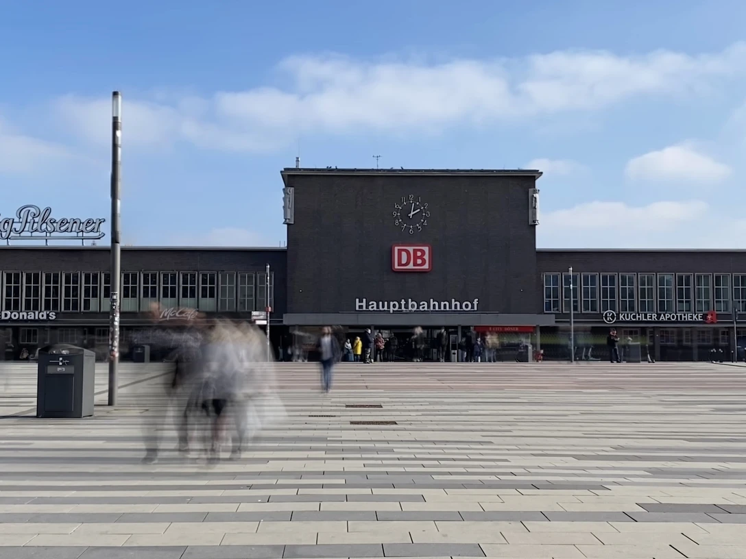 Hoofdstation Duisburg Hauptbahnhof Duisburg mit DB-Logo und Menschen auf großem Platz an einem klaren, sonnigen Tag.Duisburg main station with DB logo and people in a large square on a clear, sunny day.Duisburg Centraal Station met DB-logo en mensen op een groot plein op een heldere, zonnige dag.