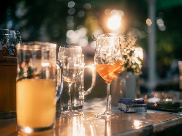 Biergarten in Einbeck Gläser auf einer Bierbankgarnitur im Sonnenlicht.