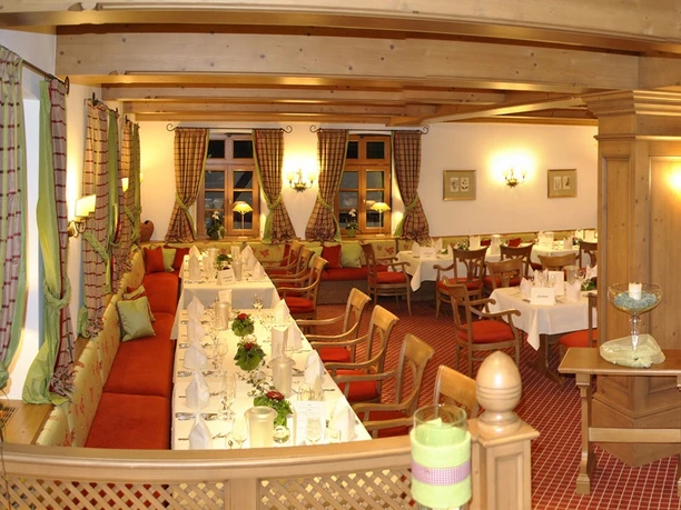 Festlich gedeckter Restaurantbereich im Landhotel Donner mit Holzbalken und roten Polstern
