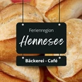 Bäckerei Ferienregion Hennesee Mehrere goldbraune Brötchen sind übereinander gestapelt, beschriftet als "Ferienregion Hennesee".