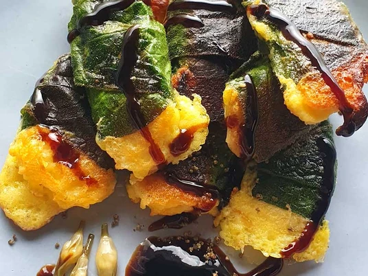 Essbare Wildpflanzen im Neanderthal - Sandra Hoitz Köstlich aussehende gebratene Blätter in einem knusprigen Teigmantel mit dunkler Sauce garniert.