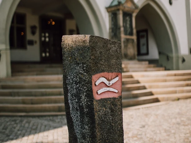 Basaltsäule mit Rothaarsteig-Logo vor dem Rathaus Brilon
