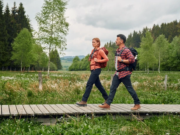 Zwei Wandernde auf einem Holzsteg am Rothaarsteig bei Küstelberg