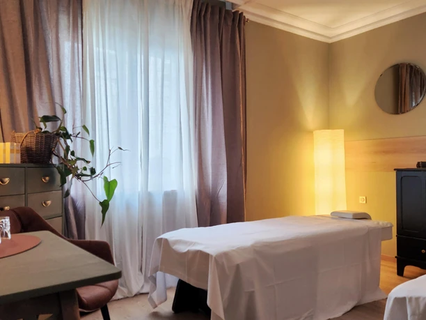 Behandlungsraum von Scaria Wellness mit Massageliege, Kerzenlicht und warmen Lampen