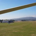Flugplatz in Ober-Mörlen Flugplatz in Ober-Mörlen mit mehreren Segelfliegern am Boden. Im Hintergrund ist der Große Feldberg zu sehen.