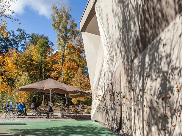 Die Boulderwand liegt zwischen Eingang zur Tourist-Info und dem Waldtraut Blick von der Boulderwand zum Außenbereich des Restaurant Waldtraut