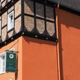 Paderborner Brauhaus Historisches Fachwerkgebäude mit orangefarbener Fassade und Brauereischild an der Hauswand.