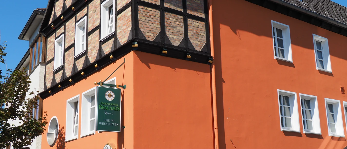 Paderborner Brauhaus Historisches Fachwerkgebäude mit orangefarbener Fassade und Brauereischild an der Hauswand.