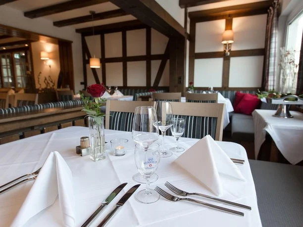 Restaurant im Holländer Hof mit gedeckten Tischen, Fachwerkdetails und roten Rosen