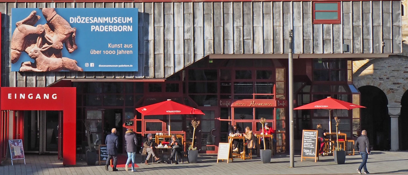 Café Ostermann am Museum mit roten Sonnenschirmen und Außenbereich neben Diozesanmuseum.