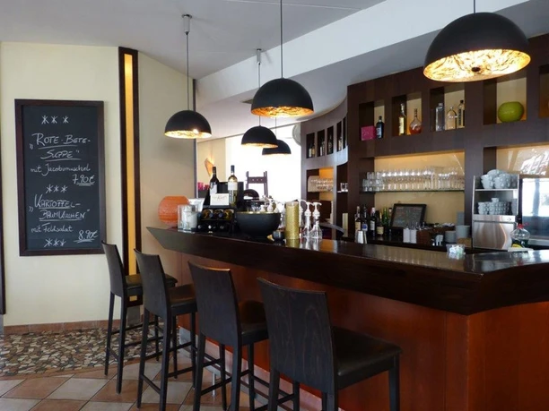 Barbereich im von Korff's mit Theke, Hockern, Pendelleuchten und Angebotstafel