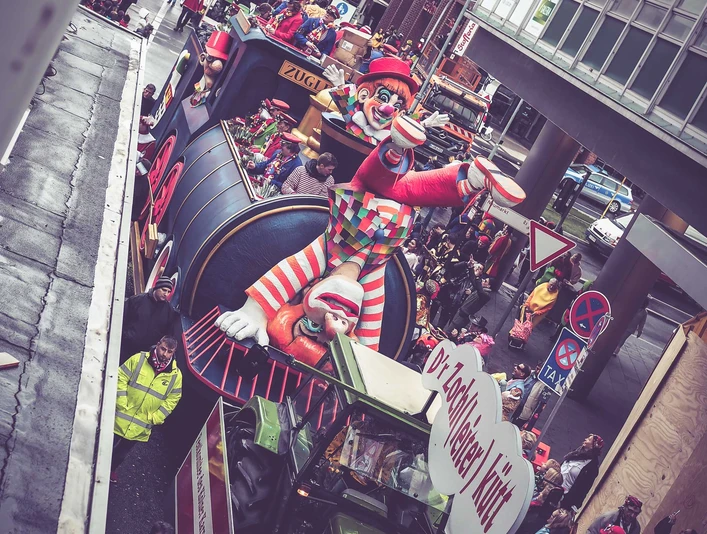 Karneval_1.jpg Ein bunter Festwagen mit einem riesigen Clown und Radfahrern während eines Karnevalsumzugs.A colorful float with a giant clown and cyclists during a carnival parade.