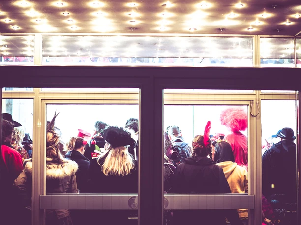 Karneval_2.jpg Karnevalsveranstaltung: Von draußen durch eine Tür fotografiert: Kostümierte Menschen stehen in einem Raum