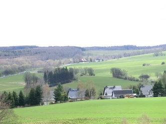Hellendorf Grenzübergang Blick auf eine weite, hügelige Landschaft bei Hellendorf, umgeben von Feldern und vereinzelt Häusern.