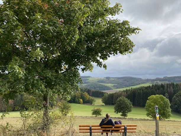Wanderin auf einer Bank im Sauerland