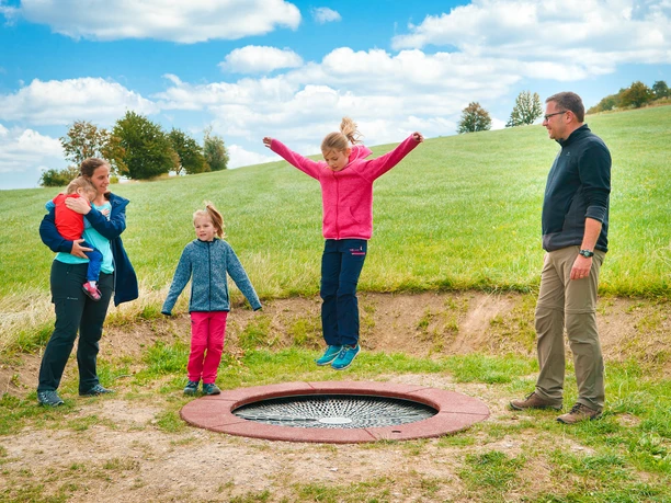 Familie am Kuhfladentrampolin auf dem Milch-Erlebnispfad Usseln