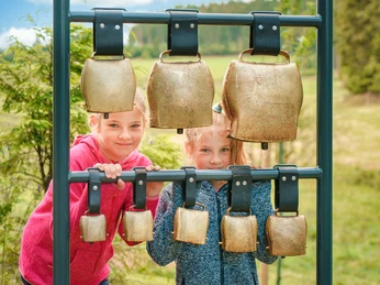 Kinder am Kuhglockenspiel auf dem Milch-Erlebnispfad Usseln