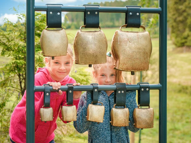Kinder am Kuhglockenspiel auf dem Milch-Erlebnispfad Usseln