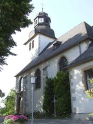 St. Sturmius Kirche Leitmar mit Turm, Schieferdach und Blumen am Eingang