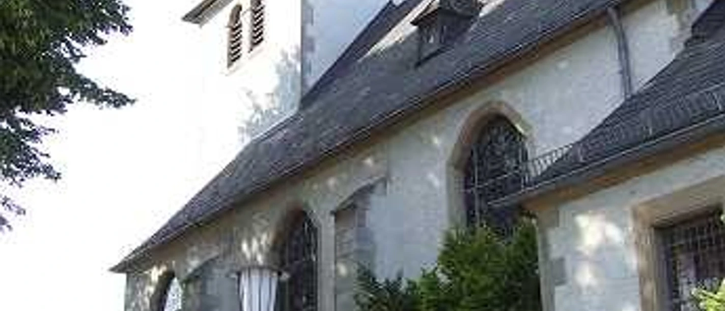 St. Sturmius Kirche Leitmar mit Turm, Schieferdach und Blumen am Eingang
