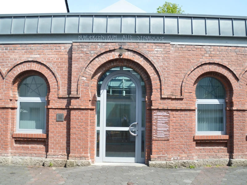 Bürgerzentrum Alte Synagoge Meschede Backsteinfassade einer ehemaligen Synagoge mit rundbogigen Fenstern und Metalltür.