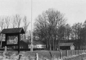 buettendorf-benkhofer-muehle-alter-standort.jpg Schwarz-weiß Fotografie eines alten Mühlenstandorts mit Schautafel und Bäumen im Hintergrund.