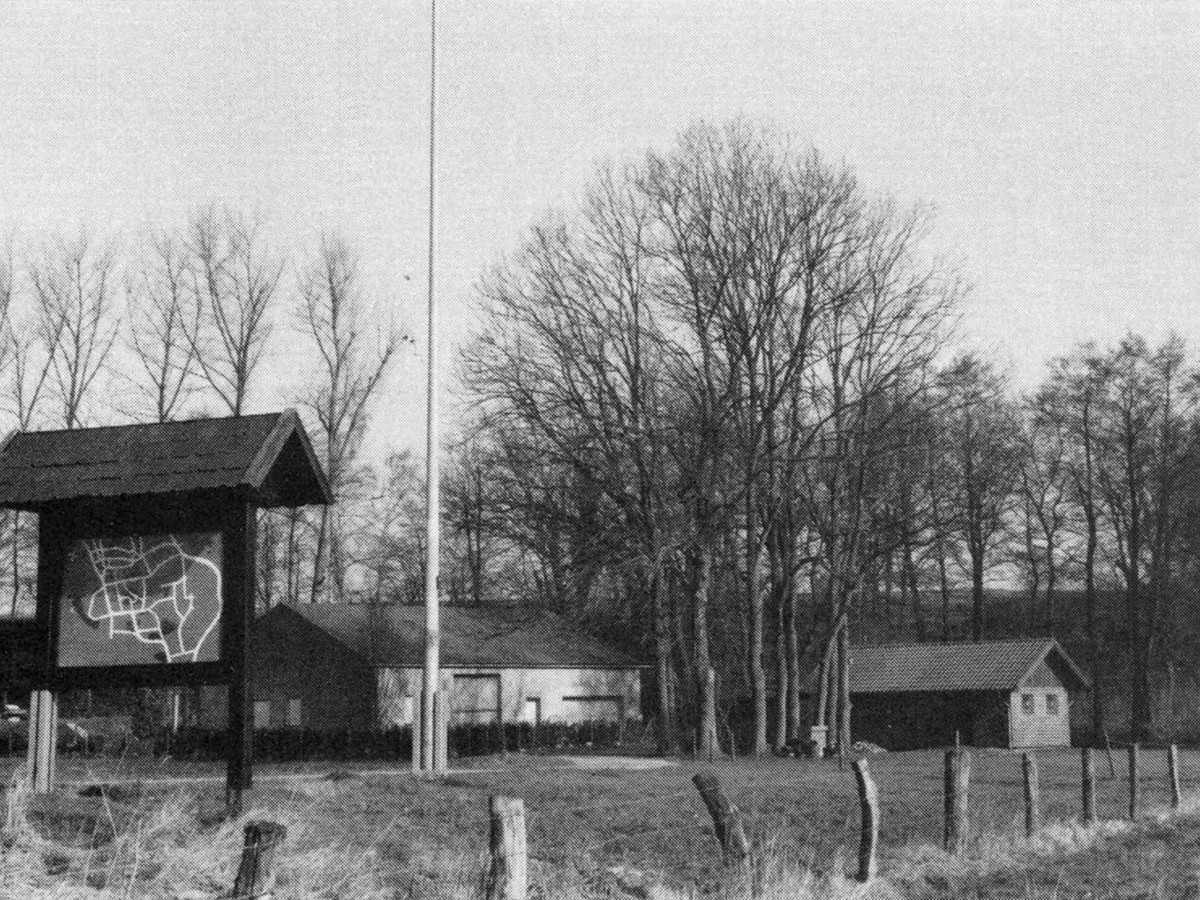 buettendorf-benkhofer-muehle-alter-standort.jpg Schwarz-weiß Fotografie eines alten Mühlenstandorts mit Schautafel und Bäumen im Hintergrund.