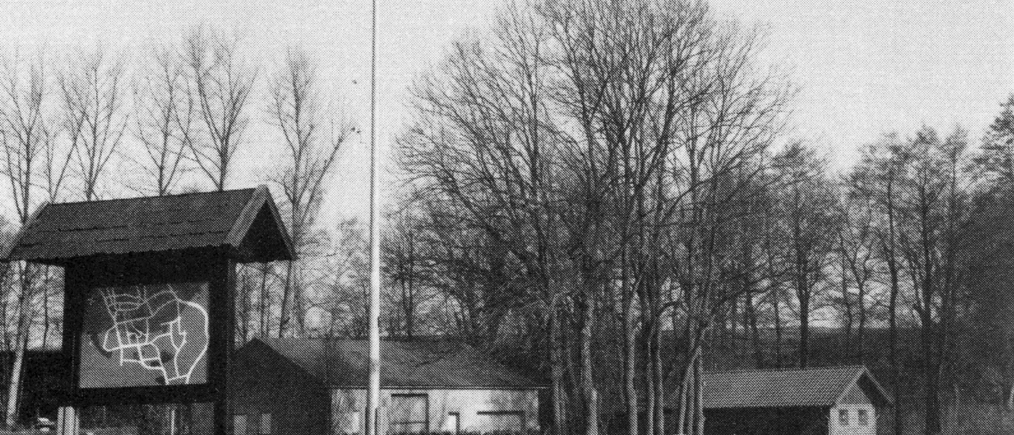 buettendorf-benkhofer-muehle-alter-standort.jpg Schwarz-weiß Fotografie eines alten Mühlenstandorts mit Schautafel und Bäumen im Hintergrund.