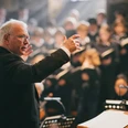 Ein Chorleiter dirigiert mit den Domchor bei einem festlichen Konzert.