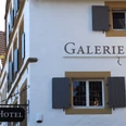 La Petite Galerie Weißes Gebäude im traditionellen Stil mit Holzfensterläden und einem Schild mit der Aufschrift "Hotel".