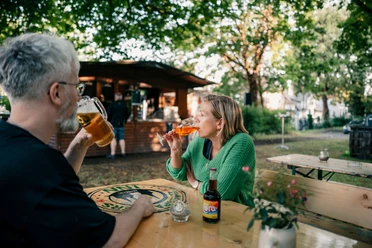 Biergarten Zwei Personen sitzen zusammen im Einbecker Biergarten und trinken Kaltgetränke.