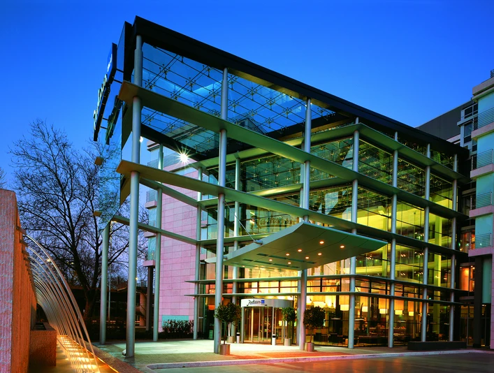 Exterior Modernes Gebäude mit Glasfassade, beleuchtet in der Dämmerung, zeigt architektonische Eleganz.</p>Modern building with glass façade, illuminated at dusk, shows architectural elegance.</p> <p