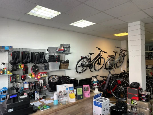 Rademachers Radshop Rademachers Radshop: Innenansicht mit Fahrrädern, Zubehör an der Wand und Empfangstheke.