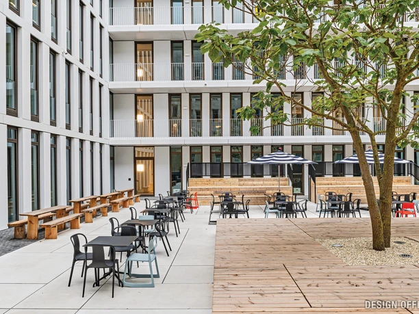 Innenhof Moderner Innenhof mit Sitzbereichen, Bäumen und hohen Glasgebäuden im Hintergrund.</p>