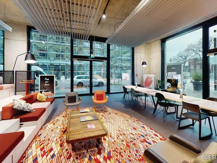 Lounge Das Bild zeigt ein modernes, einladendes Büro mit großen Fenstern, stilvollen Sitzbereichen und Tischen.The picture shows a modern, inviting office with large windows, stylish seating areas and tables.